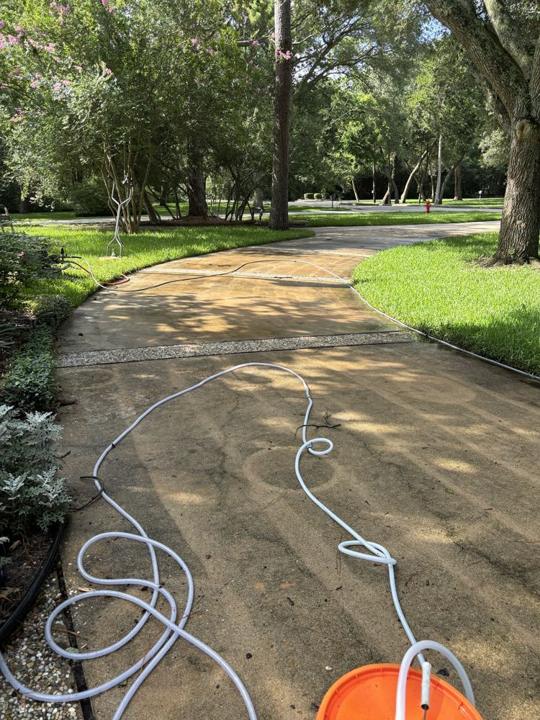 Curved driveway with hoses before cleaning