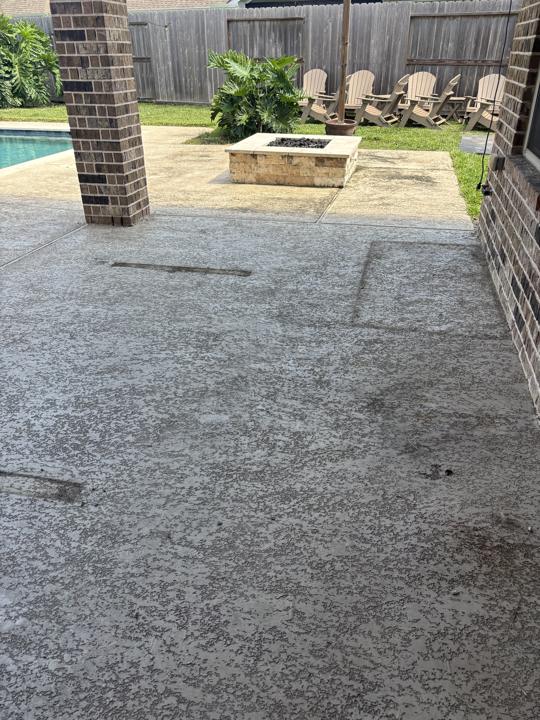 Textured concrete patio with fire pit before cleaning