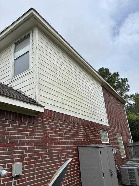 Two-story siding and brick before cleaning
