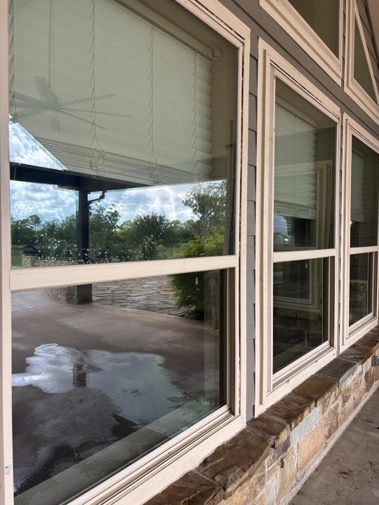 Stacked windows on gray siding after cleaning