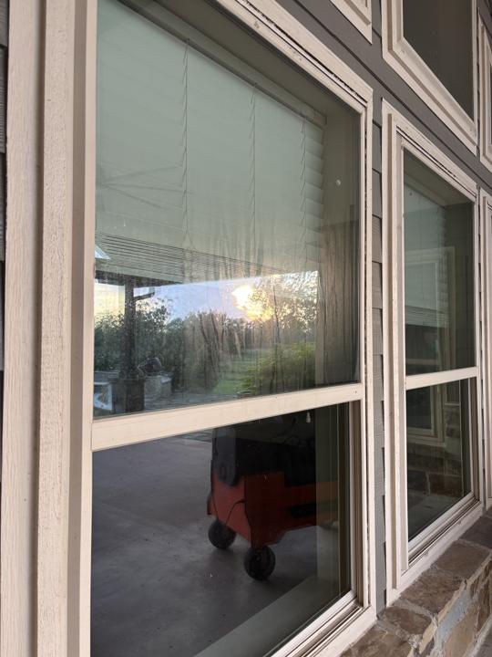 Stacked windows on gray siding before cleaning